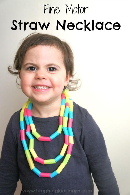 Littler girl with straw necklace on- threading fine motor skills activity