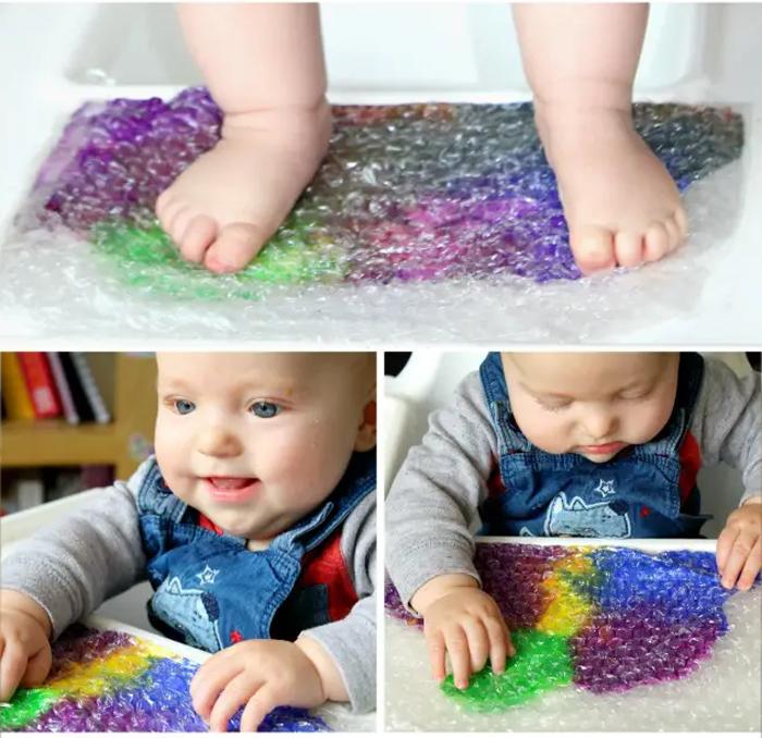 Image shows a baby playing with colored bubble wrap. Idea from Arty Crafty Kids