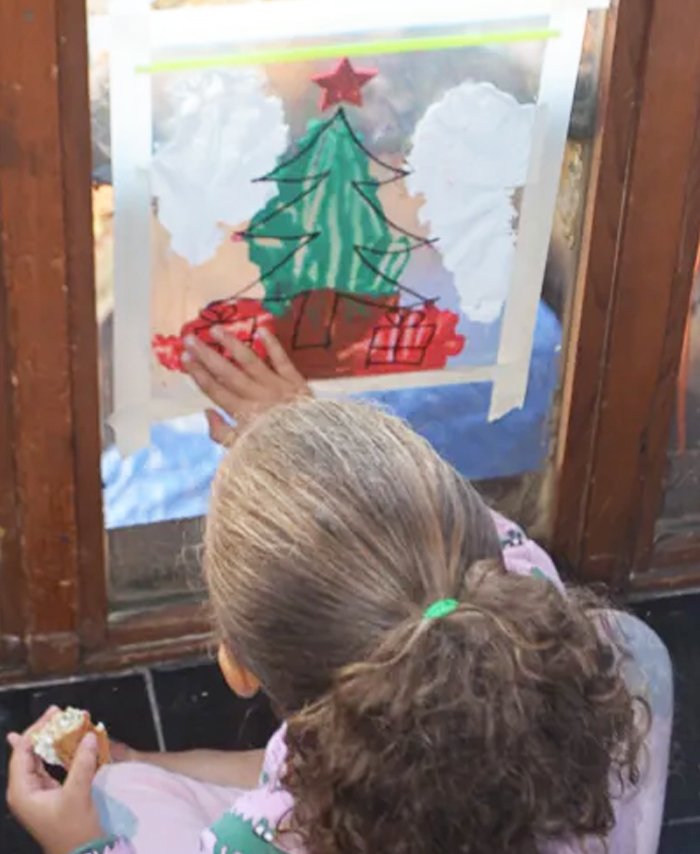 Image shows a kid painting a Christmas tree. Idea from Happy Toddler Playtime