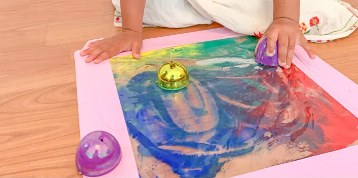 Image shows a kid doing a mess-free easter egg painting. Idea from Happy Toddler Playtime