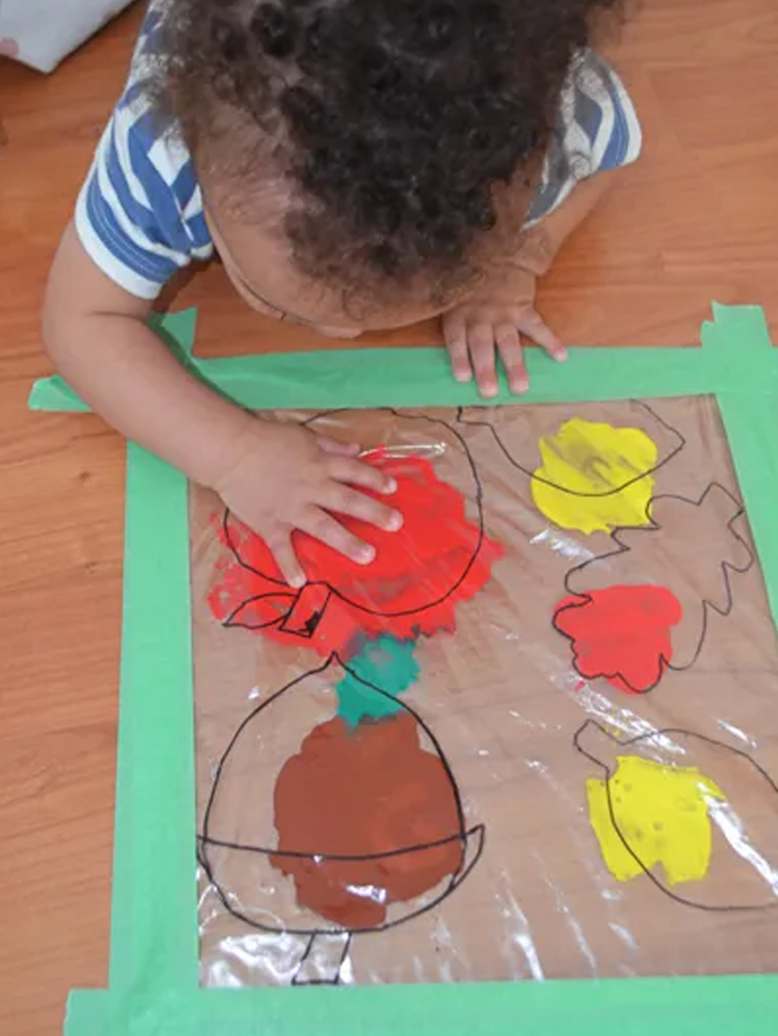 Image shows a toddler doing a fall free-mess painting. From Happy Toddler playtime