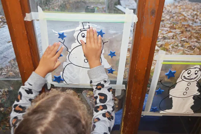 Image shows a toddler doing a mess-free snowman painting. Idea from Happy Toddler Playtime
