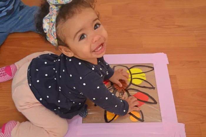 Image shows a toddler painting a Thanksgiving painting. From Happy Toddler Playtime