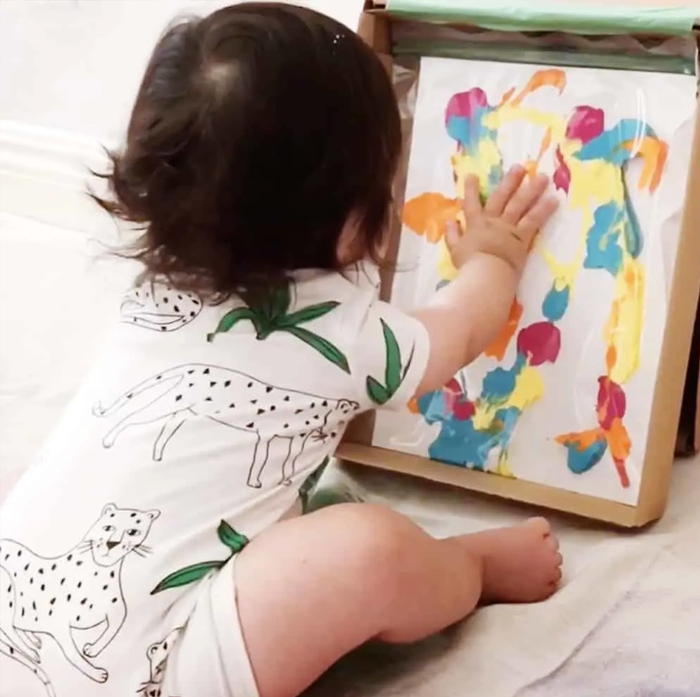Image shows a toddler doing mess-free finger painting. From Hello Wonderful.