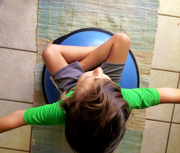Image shows a kid doing a bosu exercise. From KAB