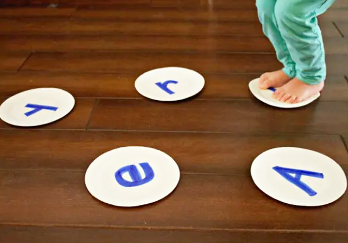 Image shows a kid jumping on letters on the floor. Idea from Fantastic Fun And Learning