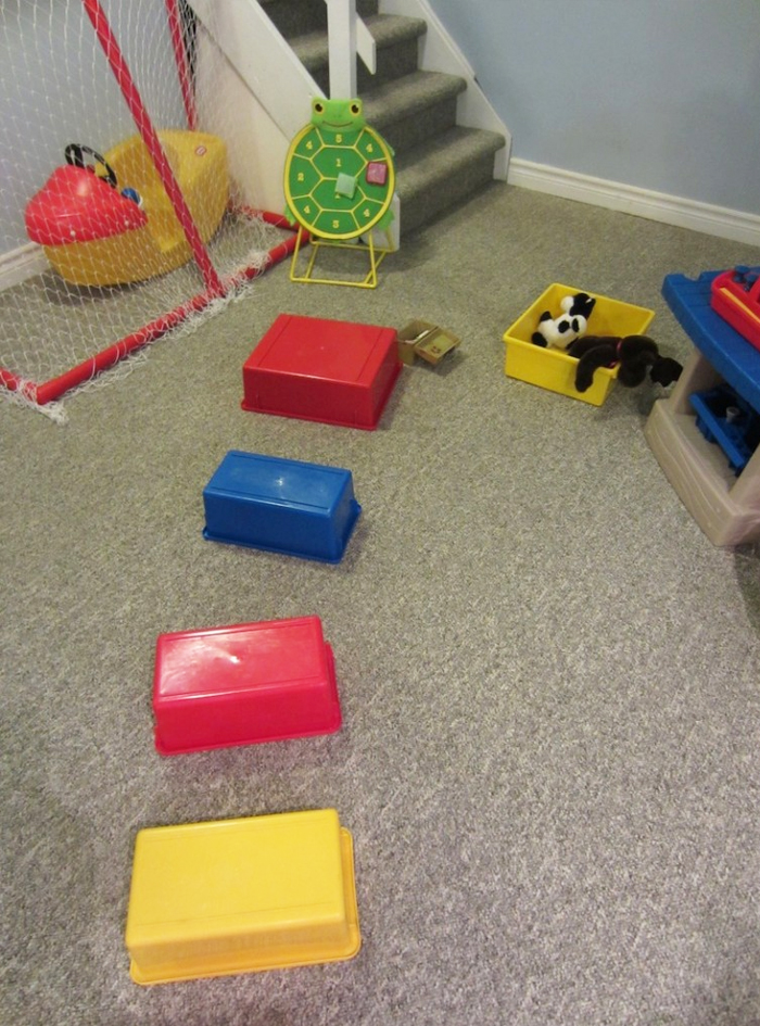 Image shows an indoor obstacle course with home objects. Idea from How to run a homeday care
